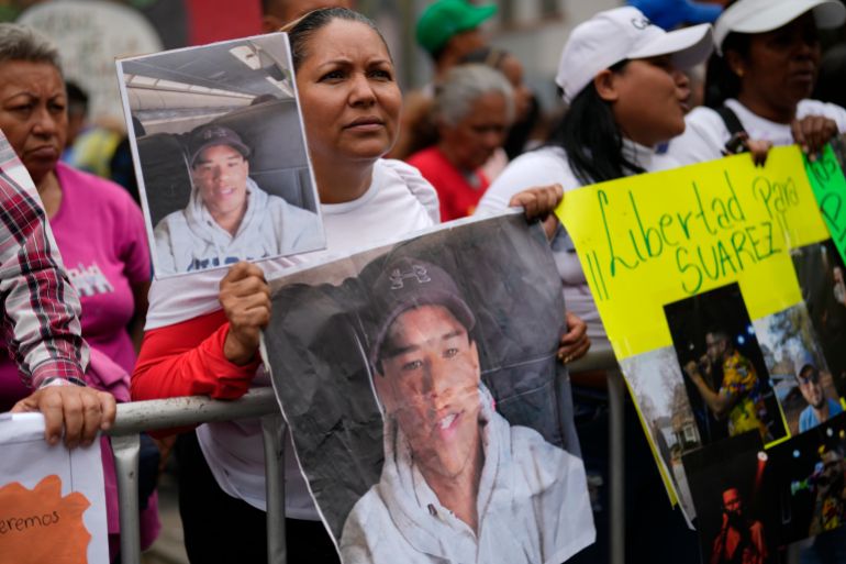 Protesters hold up photos of Venezuelans deported to El Salvador from US