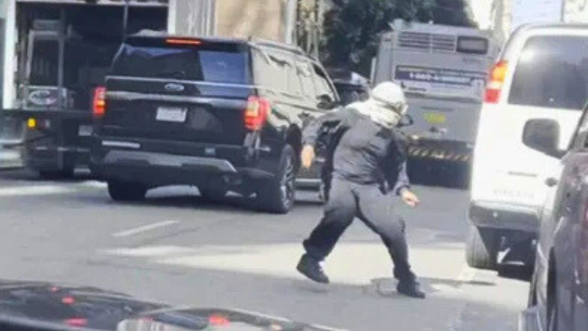 Keffiyeh-clad protester moves toward federal vehicles near 100 Montgomery St. in San Francisco