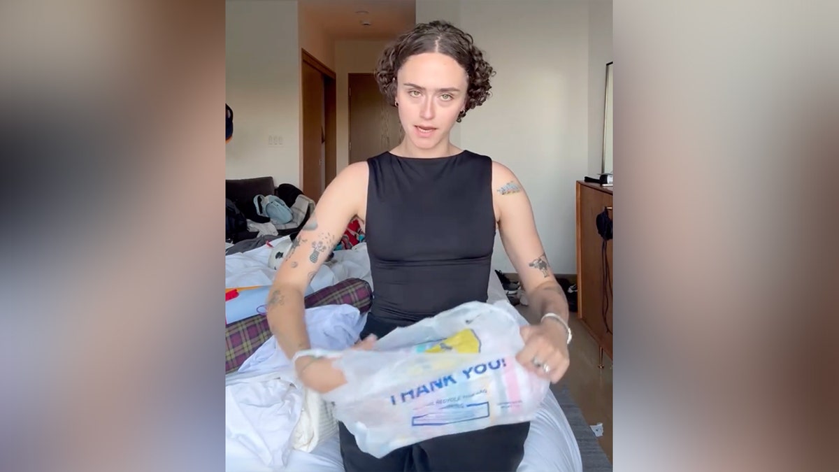 Ella Emhoff sits on a bed with a plastic bag.