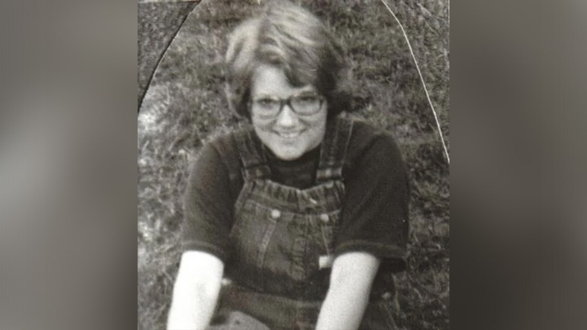 Kristin David, wearing glasses and overalls.