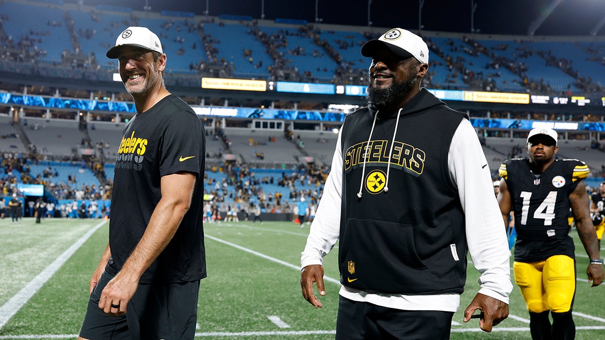 Aaron Rodgers and Mike Tomlin walk off the field
