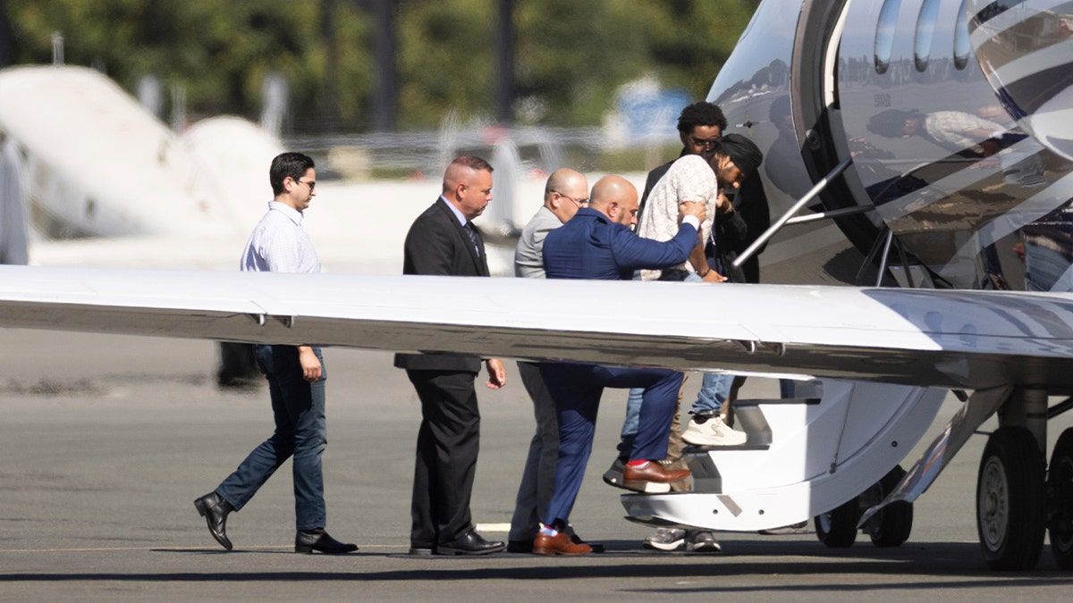 Harjinder Singh is escorted onto an airplane by law enforcement