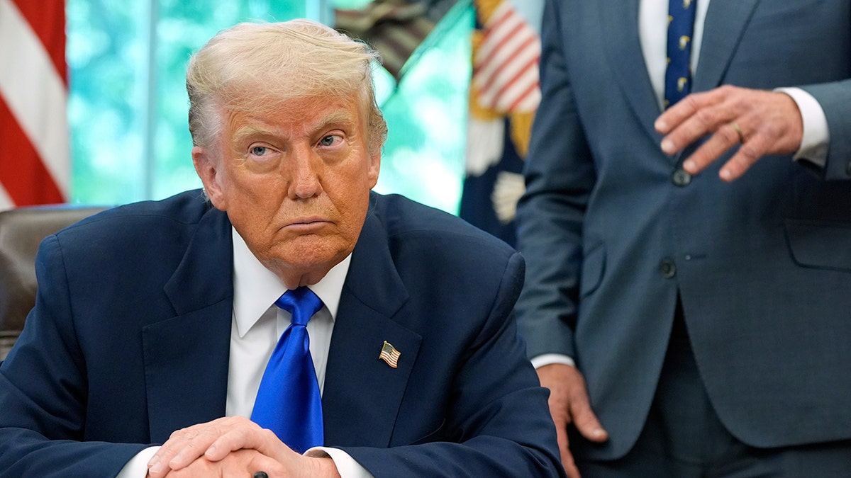 Trump at Oval Office desk during executive order signing ceremony