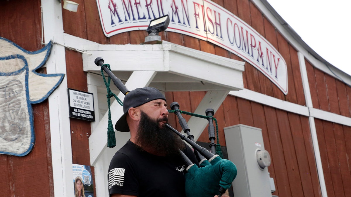 Joey Whitaker from Holden Beach plays "Amazing Grace" on the bagpipes in front of the American Fish Company