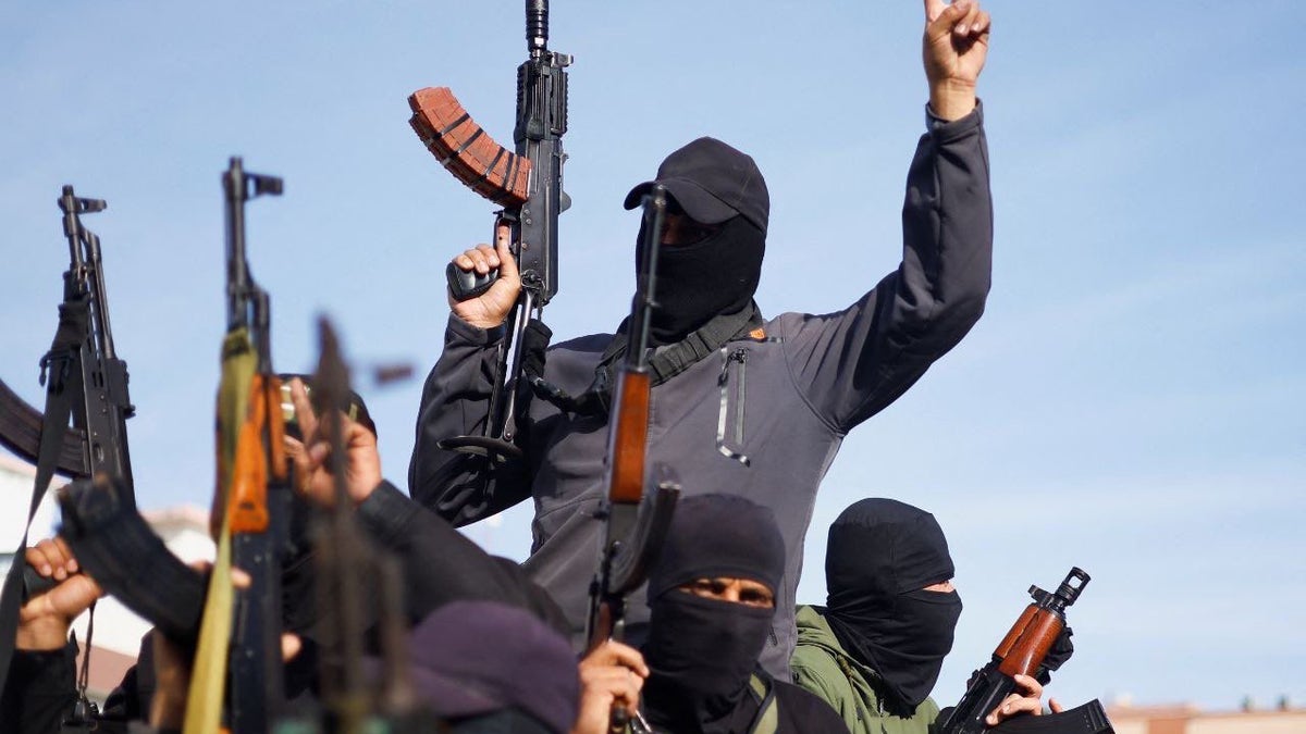 Men in black with guns in the air.
