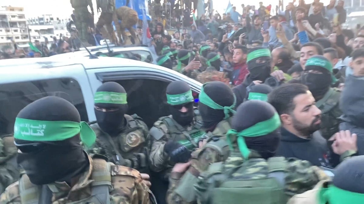 Hamas terrorists emerge in a show of strength escorting Red Cross vehicles carrying 3 Israeli hostages to be released as part of the cease-fire deal.Â