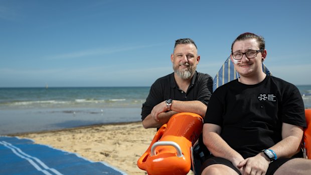 Frankston local Kayden Crombie and Frankston Councillor Nathan Butler at Frankston beach. Kayden is in one of the beach accessible wheelchairs that will form part of a new initiative to make Frankston beach more inclusive.