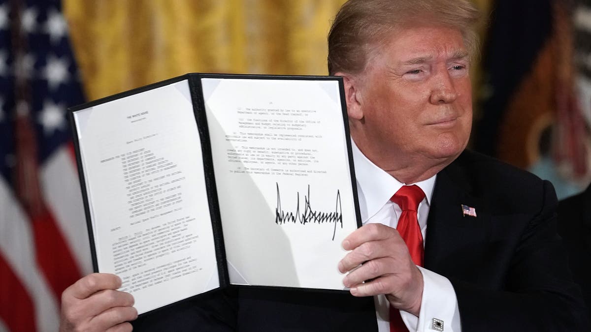 President Donald Trump holds up an executive order that he signed during a meeting of the National Space Council at the East Room of the White House to establish the Space Force, June 18, 2018, in Washington, D.C.