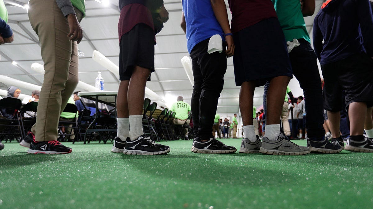 Legs of migrant children in a line