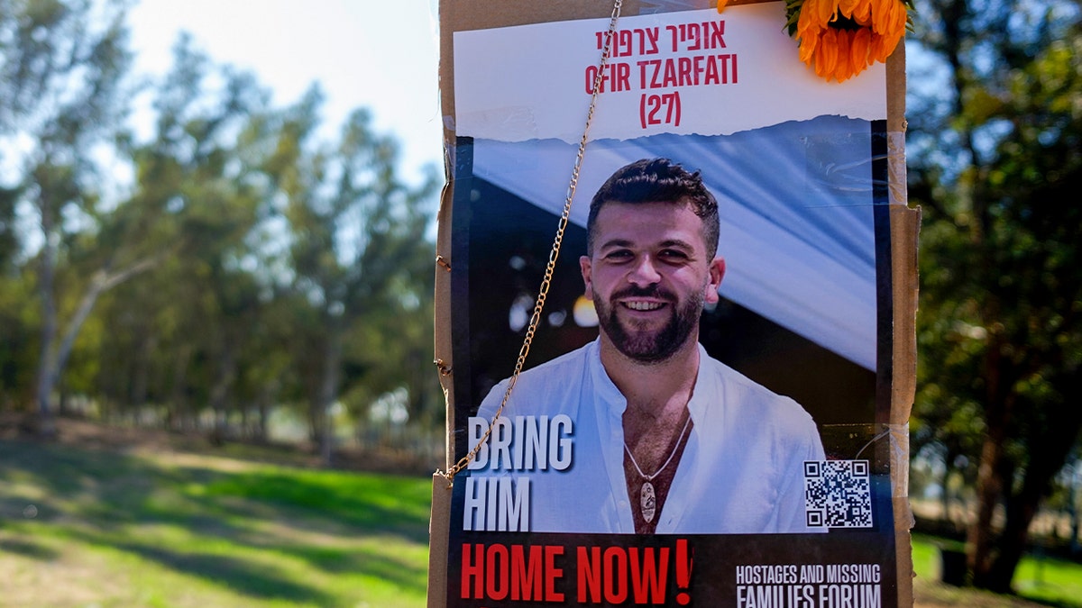 A hostage poster for Ofir Tzarfati is seen at the site of the Nova festival