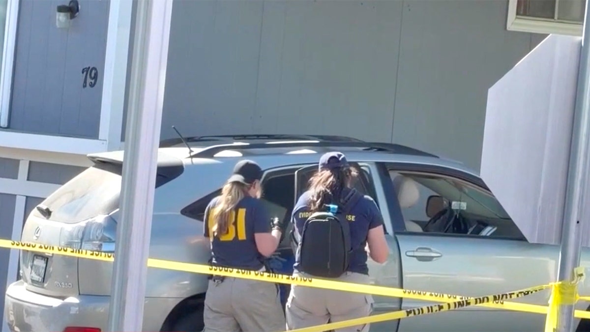 FBI agents take pictures of car.