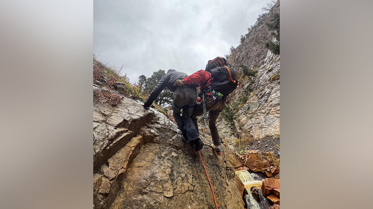 Driver and rescuer walking up ledge