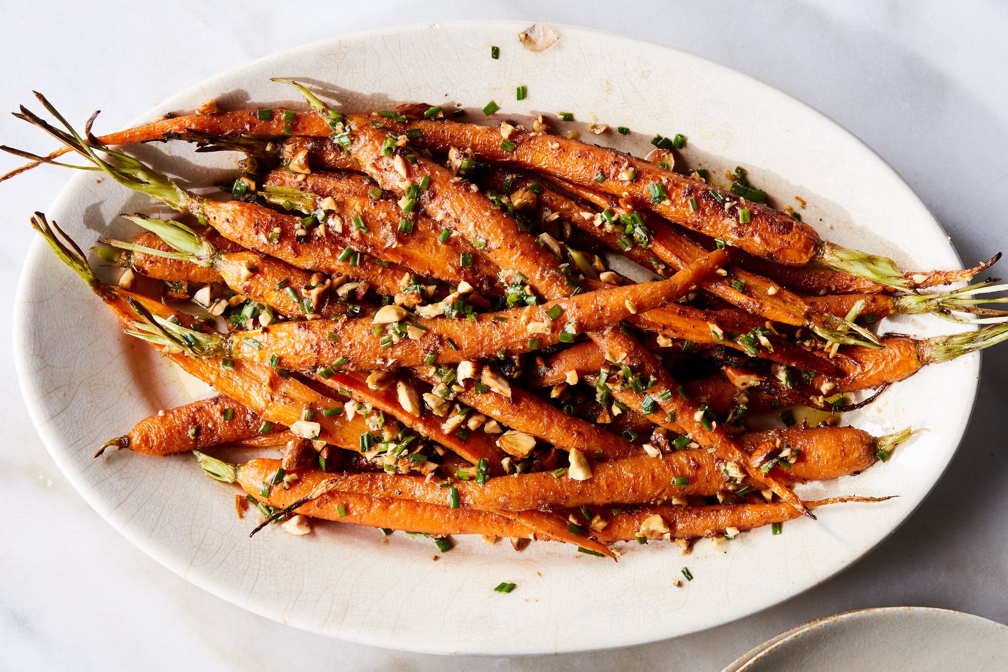 An overhead image of sliced roasted carrots topped with almonds.