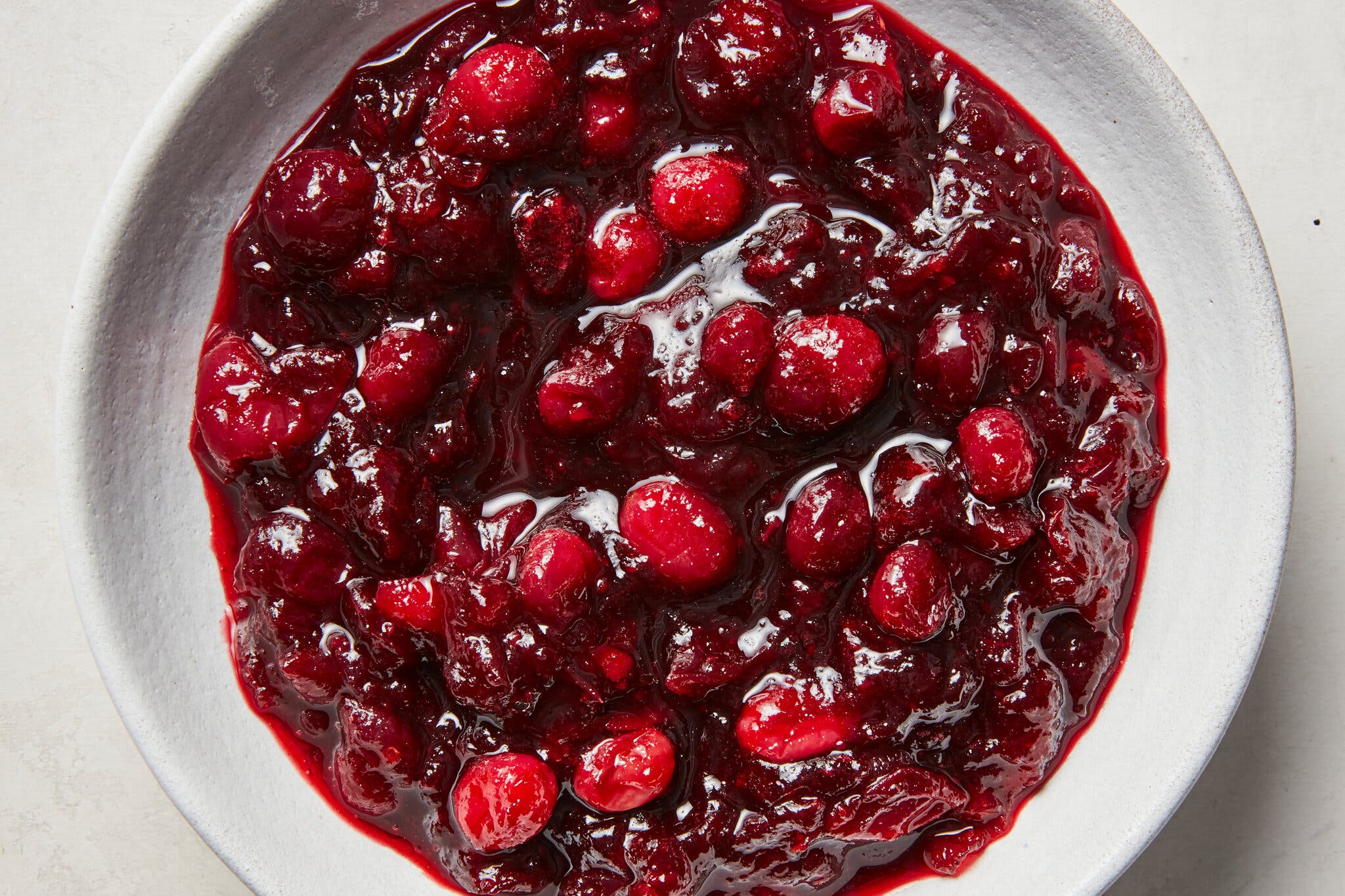 An overhead shot of a bowl of chunky cranberry sauce.