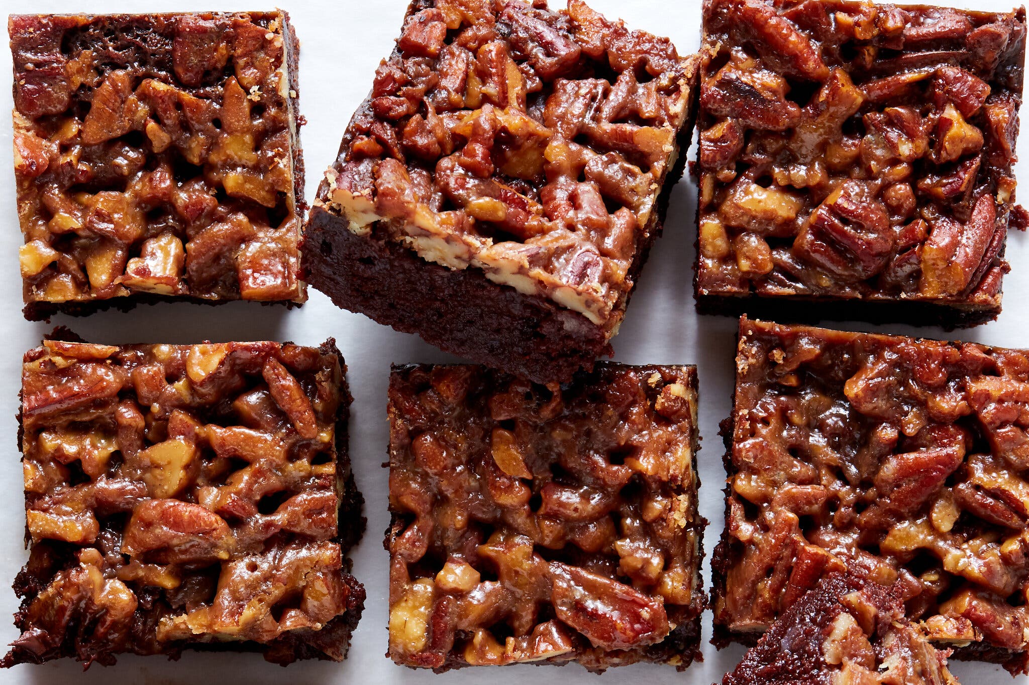 Six square brownies covered with a dense layer of shiny pecan topping. 