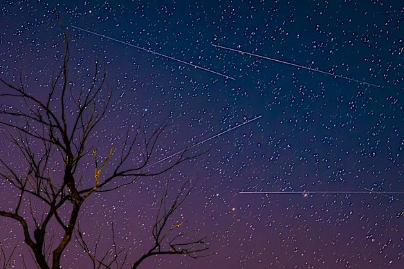 Satellites drag across the heavens as a southern aurora lights up the night sky over Blaxland, NSW.
