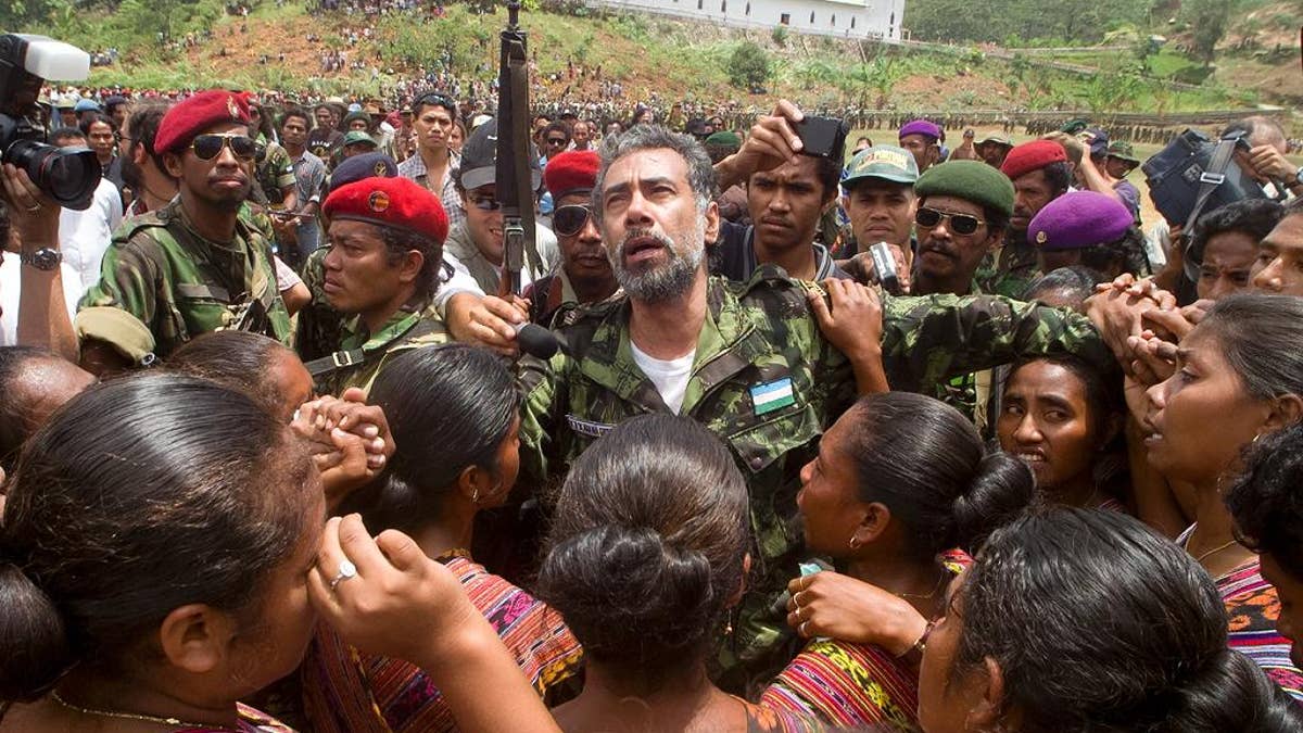 In this Oct. 24, 1999, photo, then East Timorese rebel leader Xanana Gusmao is embraced as he returns to the Armed Forces of National Liberation of East Timor (FALINTIL) rebel army camp for the first time since his release from an Indonesian prison, in Remexio, in the hills outside of Dili, East Timor. East Timor independence hero Prime Minister Xanana Gusmao resigned as prime minister Friday, Feb. 6, 2015, stepping down ahead of an expected restructuring of the government next week. (AP Photo/Charles Dharapak)