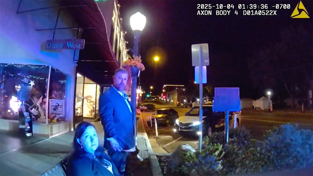 A man and woman looking at a police officer.