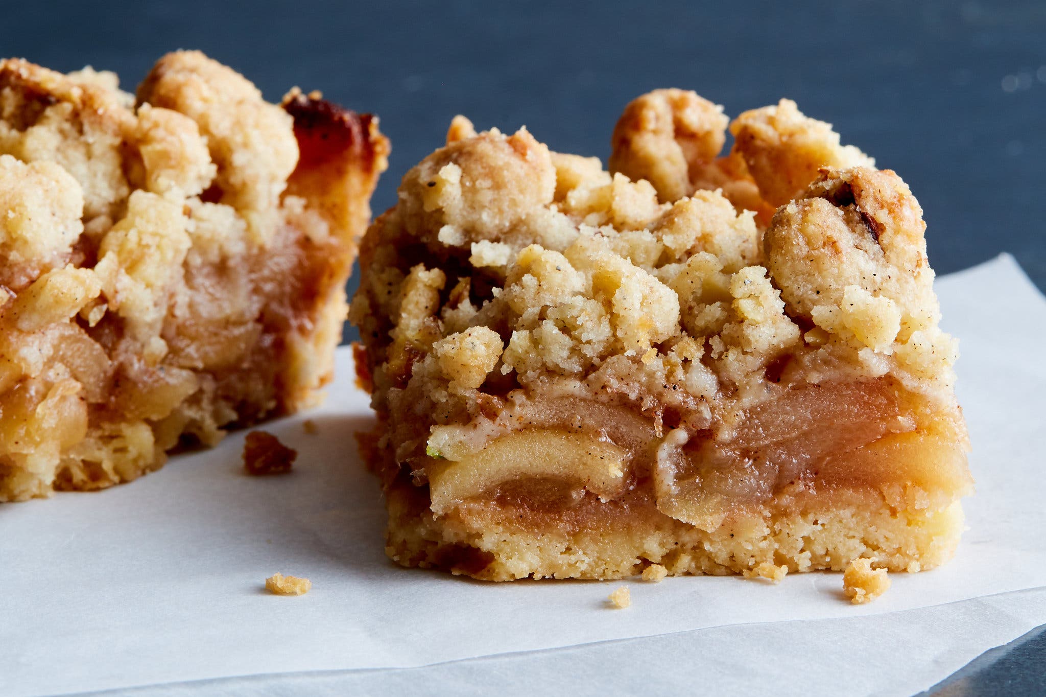 A side shot of an apple pie bar, with another bar in the background.