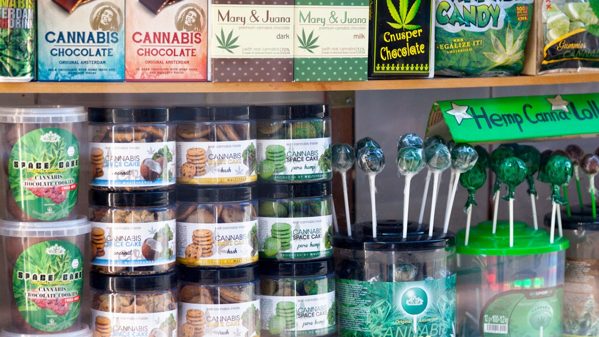 Shelf of weed products like candy, brownies, and gummies.