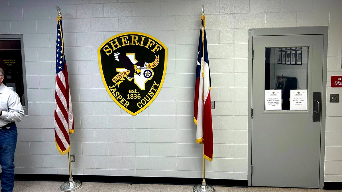 Jasper County Sheriff's Office interior with crest on wall between American flags