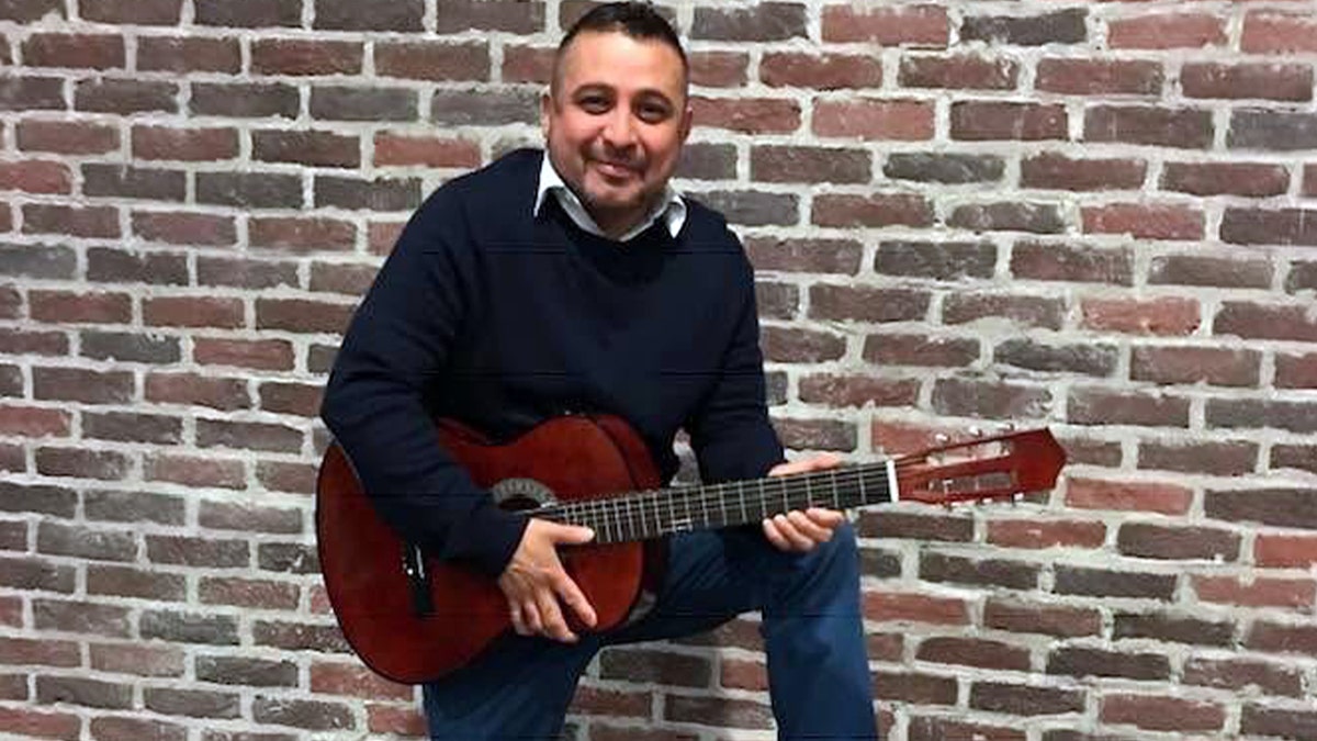 Jose Ramirez holding a guitar