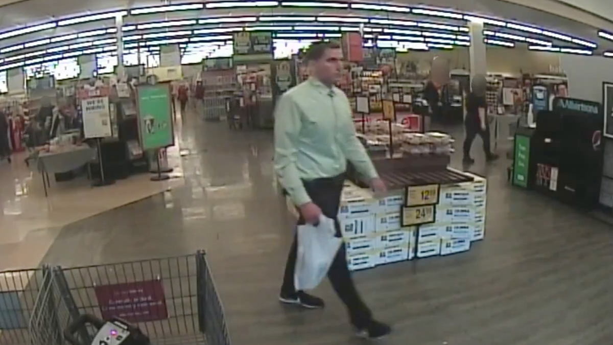 Bryan Kohberger wearing a green shirt, black pants and black sneakers, carries a shopping bag out of an Albertson's supermarket in Lewiston, ID