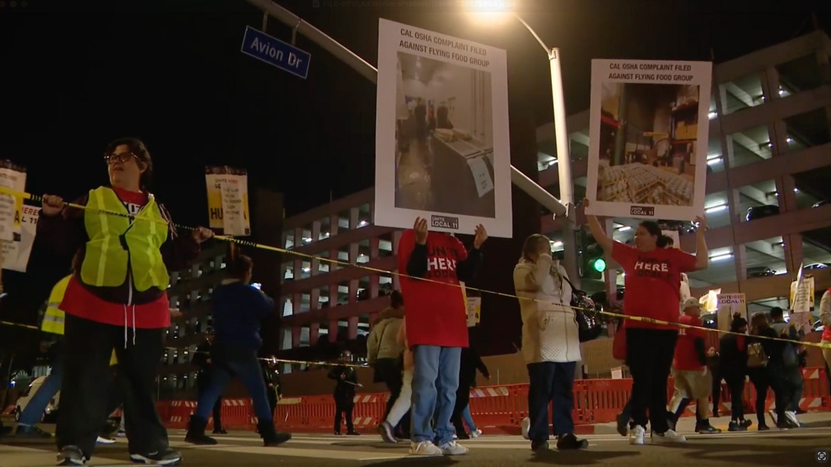 Protesters hold signs in LAX intersection