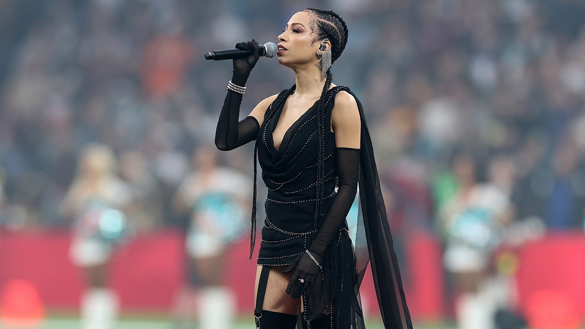 Karina Pasian wears a black mini dress to perform the US national anthem