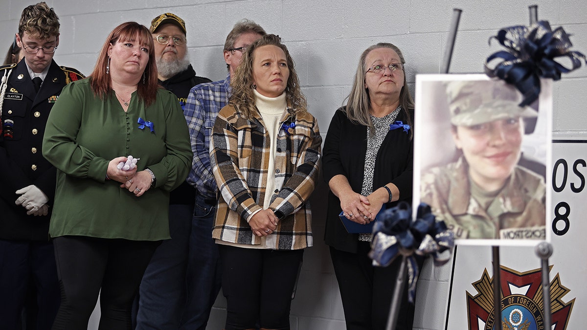 People in West Virginia stand next to poster of Sarah Beckstrom during vigil