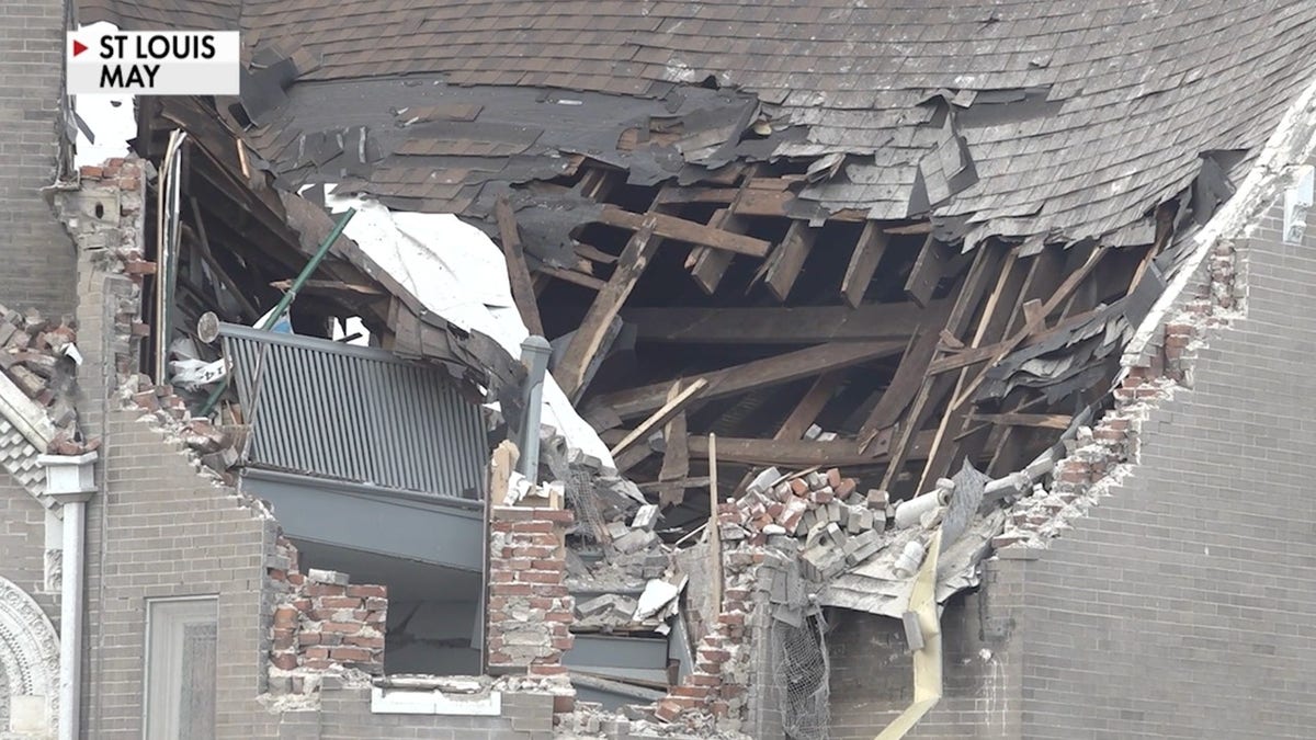 A building in St. Louis with its roof and upper wall ripped open shows extensive structural damage from the May tornado.
