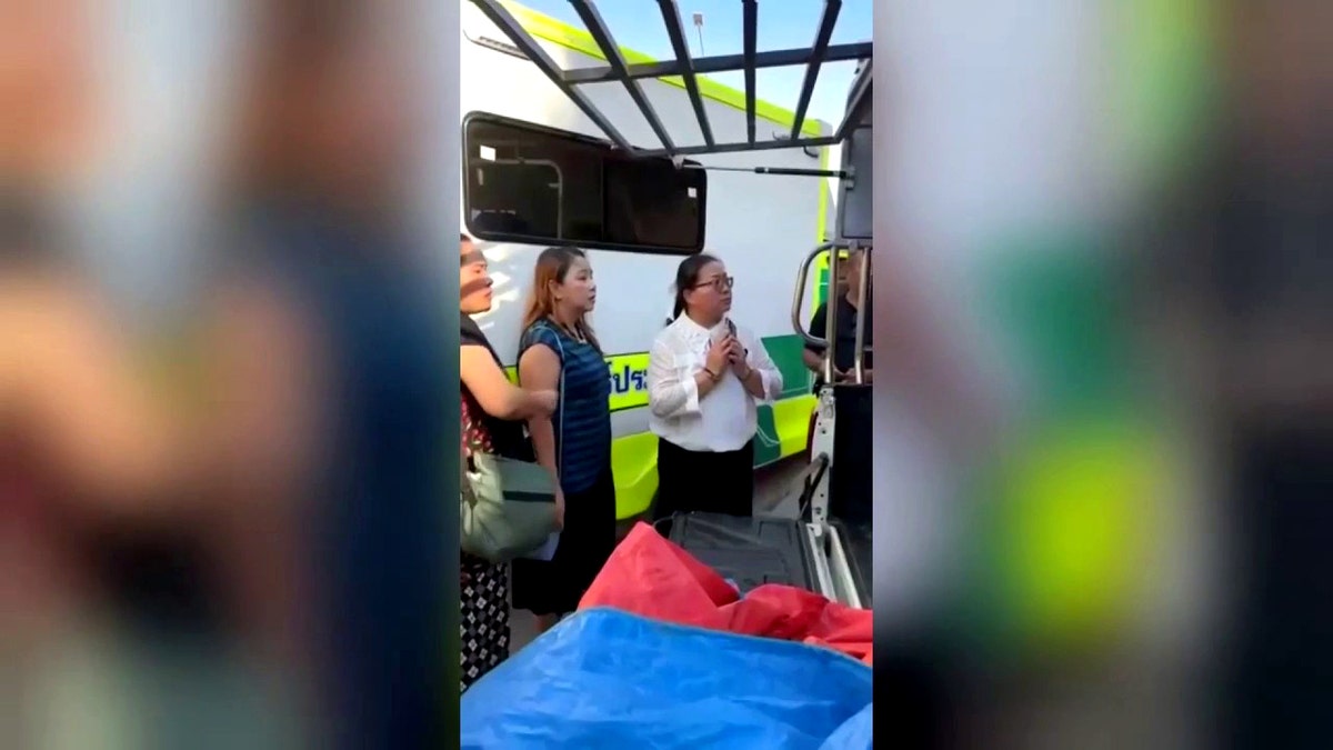 Bystanders looking shocked at the woman in the coffin