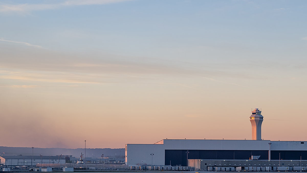 The ATC tower is seen while smoke rises from the crash site of UPS Flight 2976 near Louisville Muhammad Ali International Airport on Wednesday, Nov. 5, 2025, in Louisville, Ky.