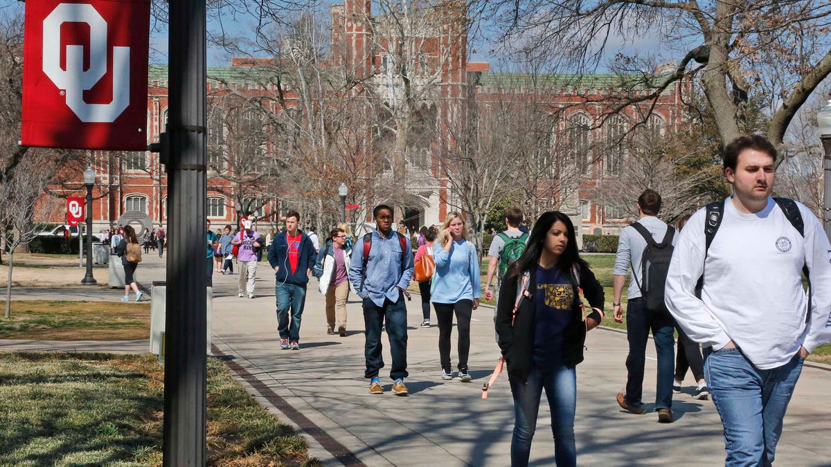 People walk on the Oval at the University of Oklahoma in Norman, Okla., Tuesday, March 10, 2015. Two students have been expelled from the university following an incident in which members of a fraternity were caught on video chanting a racial slur. (AP Photo/Sue Ogrocki)