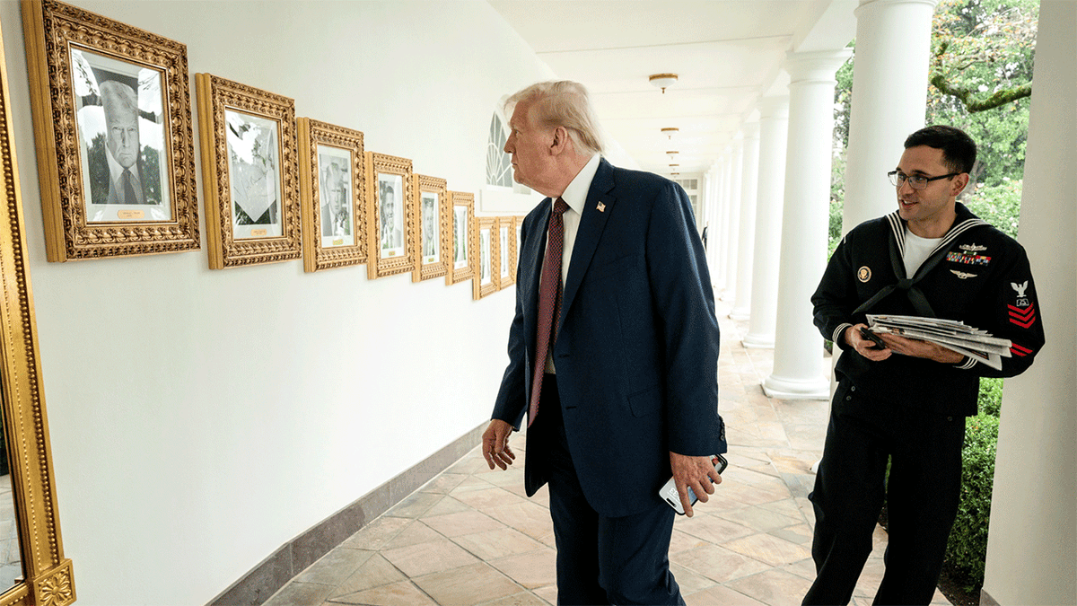 President Trump looks at images of past presidents on wall at White House