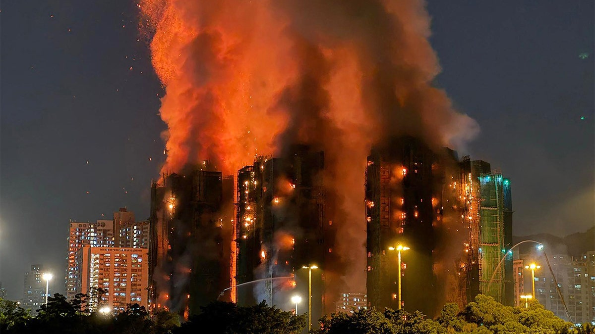 Heavy smoke and flames pour from multiple high-rise buildings during a large residential fire in Hong Kong.