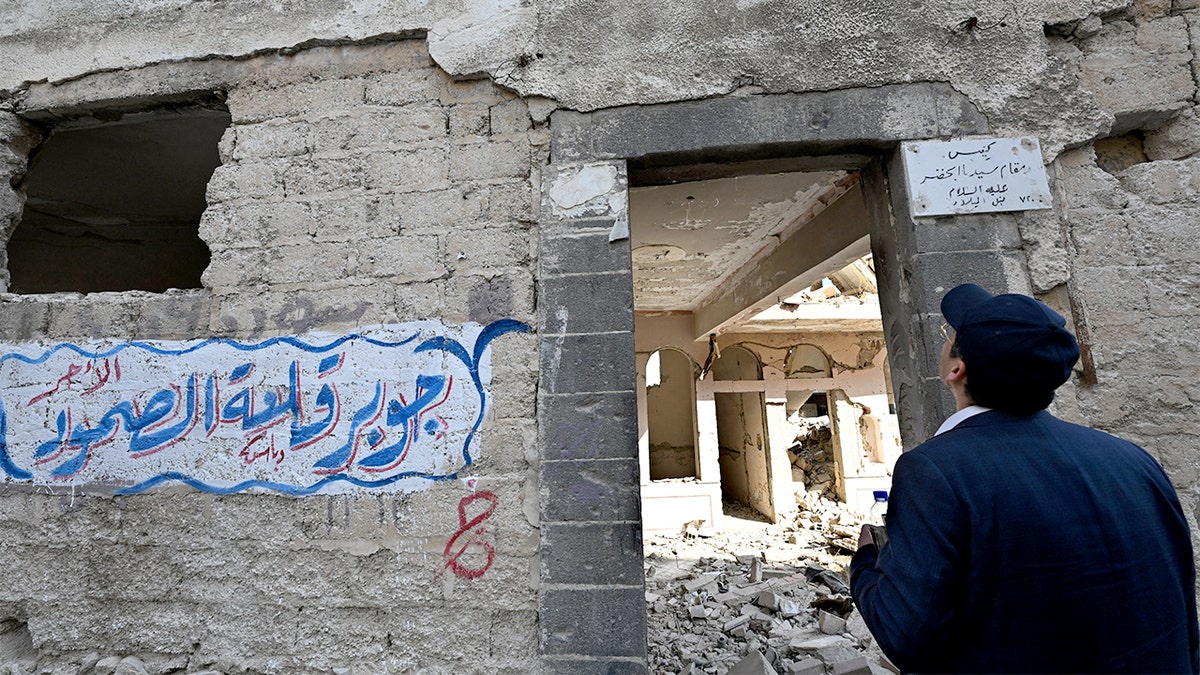 A man observes the damaged remains of a historic synagogue near Damascus.