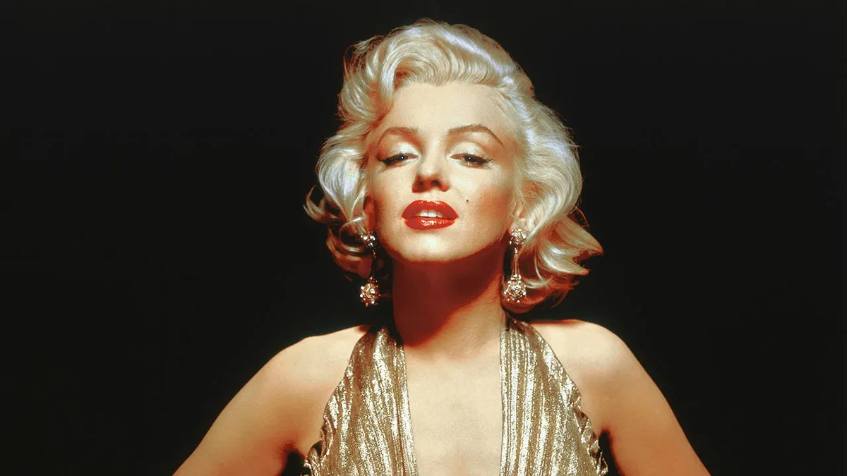 Marilyn Monroe wearing a low-cut gold dress.