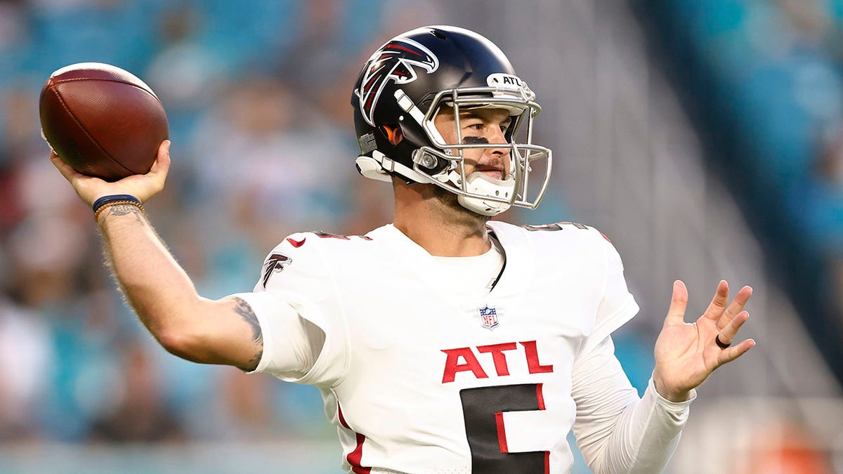 AJ McCarron throws a pass during an NFL game