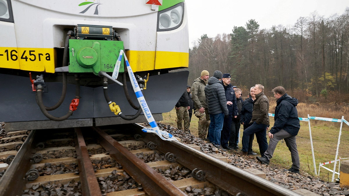 A passenger train halted on a cordoned railway line as authorities investigate an explosion site.