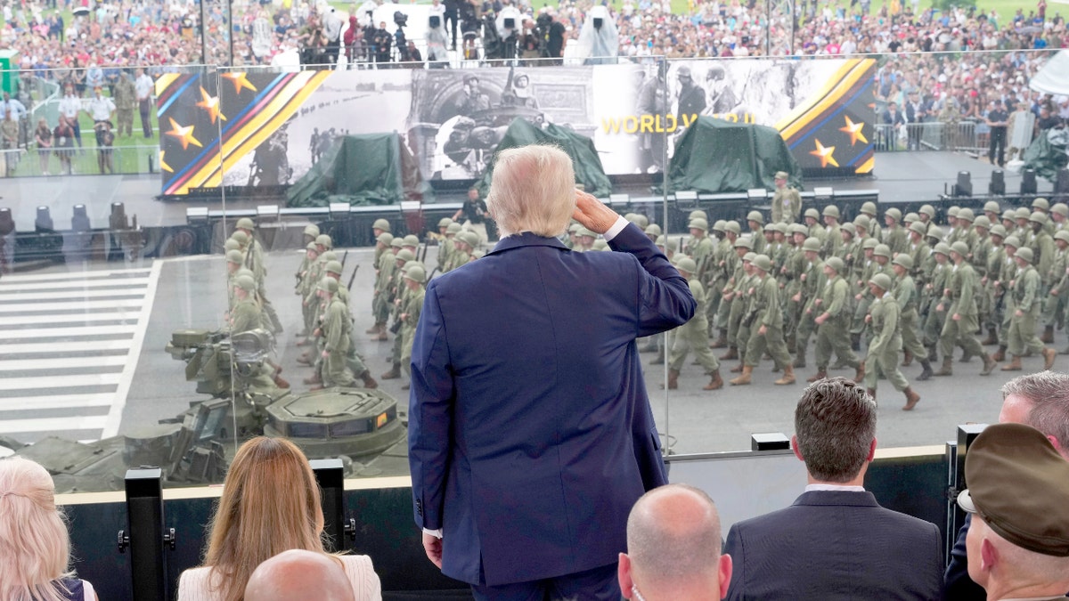 Donald Trump saluting soldiers at a military parade.