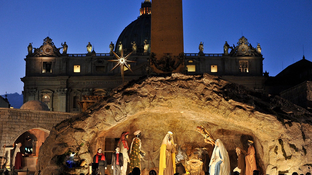 People take part during of unveiling ceremony of the crib in St Peter's