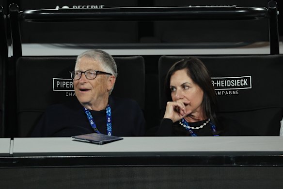 Bill Gates and Paula Hurd watch on Rod Laver Arena during the men’s doubles final.