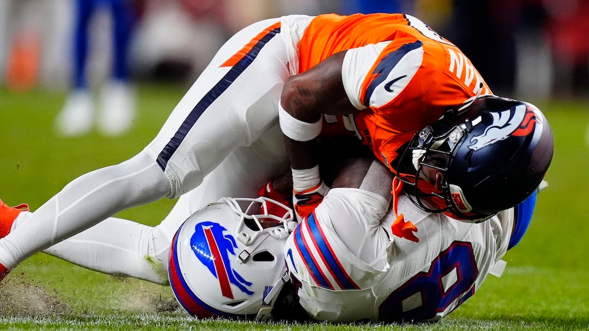 Denver Broncos cornerback Ja'quan McMillian (29) intercepts a pass intended for Buffalo Bills wide receiver Brandin Cooks (18) during overtime of an AFC Divisional Round playoff game at Empower Field at Mile High. 
