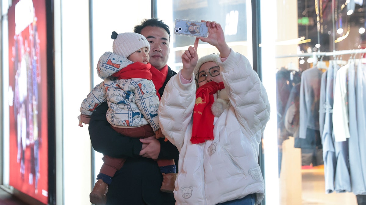 Chinese family of three takes selfie at mall