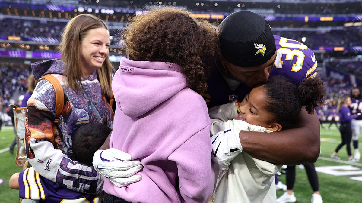 C.J. Ham embraces with family