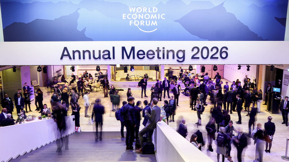 Attendees walk through a conference venue as participants gather for an international economic summit.