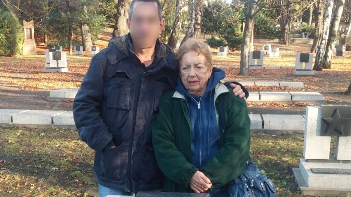 Eli Konigsberg is pictured with his mother beside the burial site of her father, his grandfather