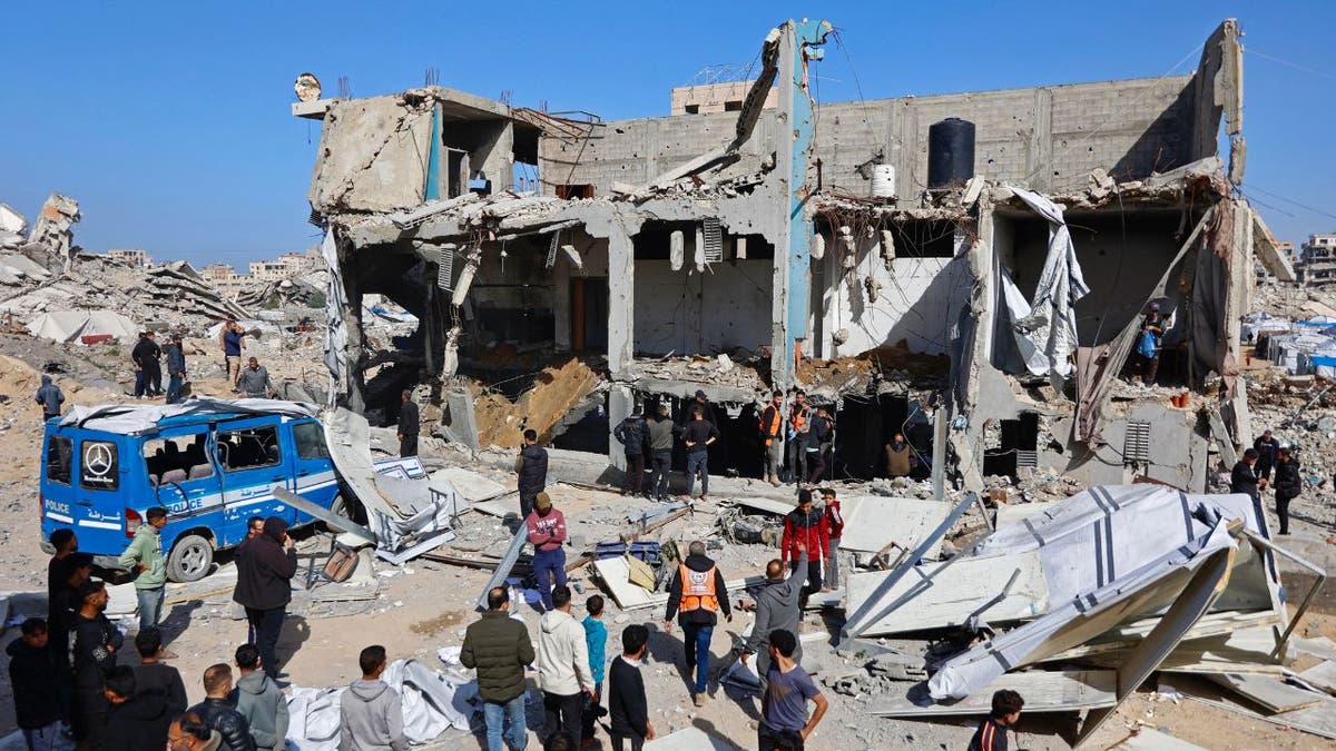 People gather around the rubble of a damaged police station in Gaza City.
