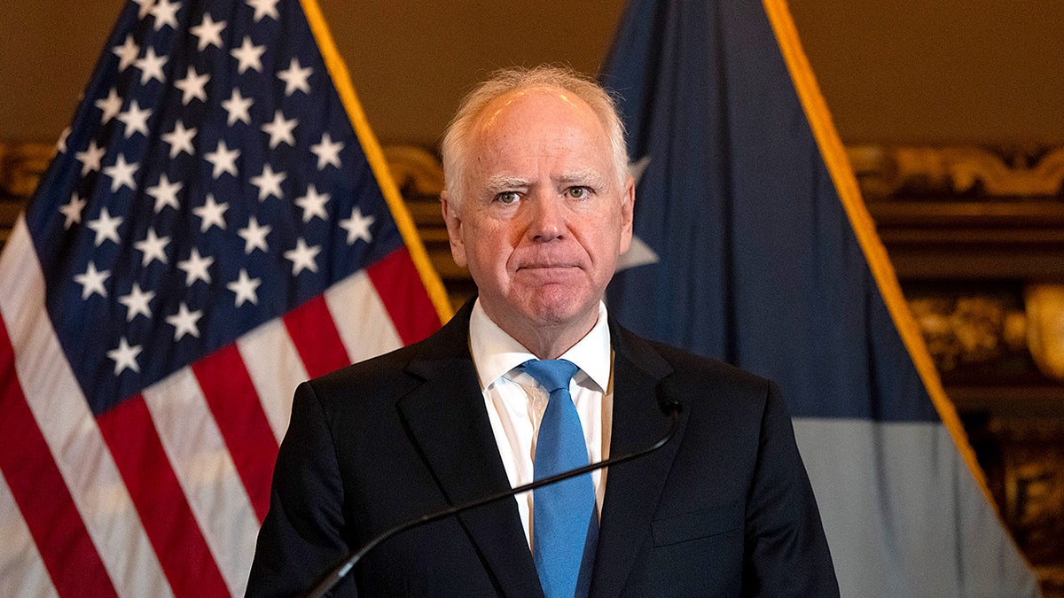 Minnesota Gov. Tim Walz stands at a podium speaking during a press conference at the State Capitol.